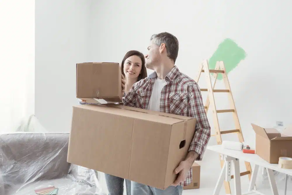 A couple moving boxes into their new home