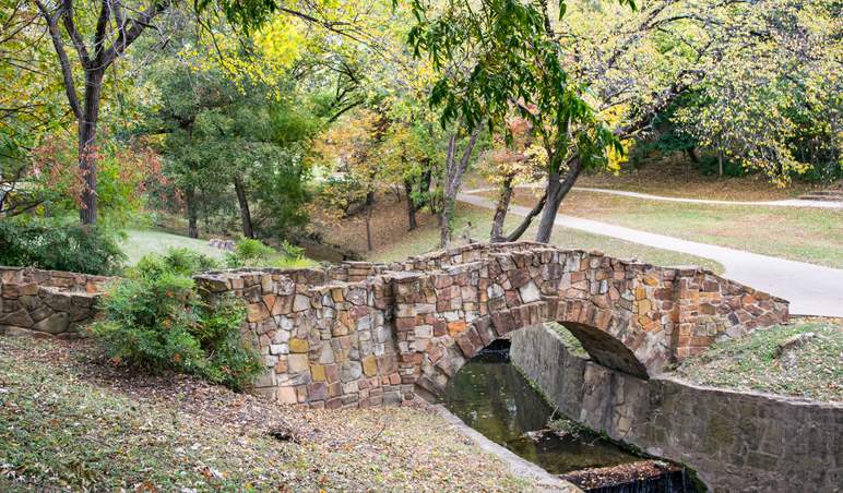 A bridge going over a small creek in the park