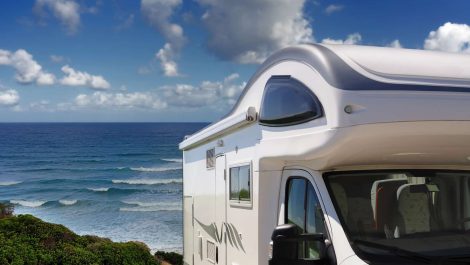 An RV parked beachside for a camping trip.