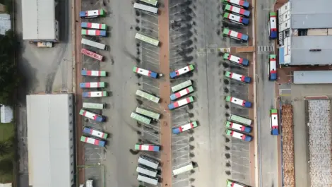 Aerial view of a truck parking lot with colorful trucks parked diagonally.