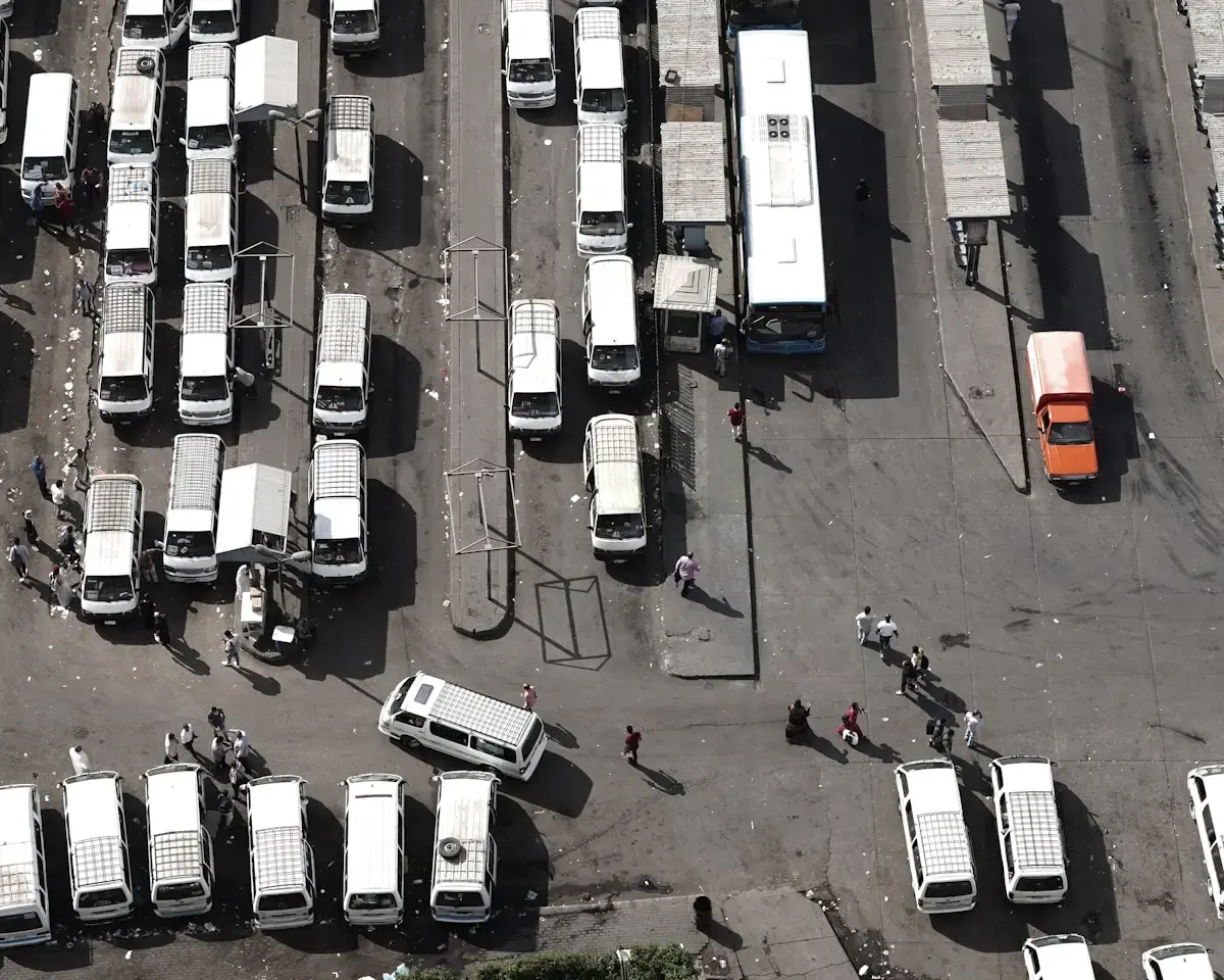 Aerial view of buses and trucks in a parking area.