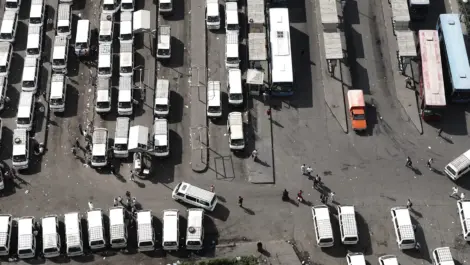 Aerial view of buses and trucks in a parking area.