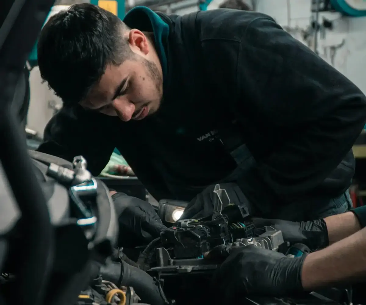 Mechanic working on a motorhome engine during maintenance.