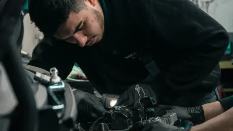 Mechanic working on a motorhome engine during maintenance.
