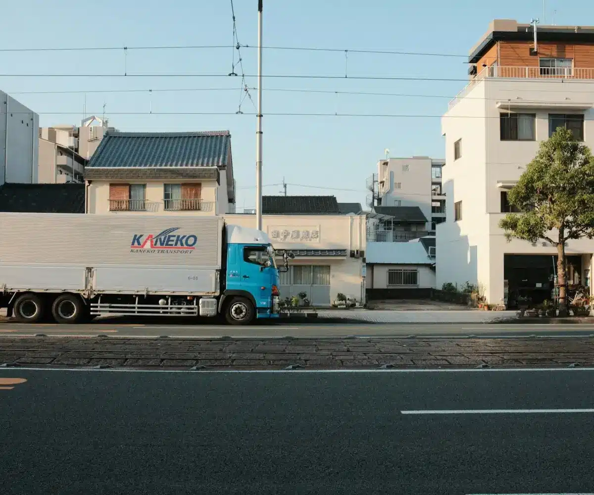 Transport truck parked in front of buildings on a quiet city street.