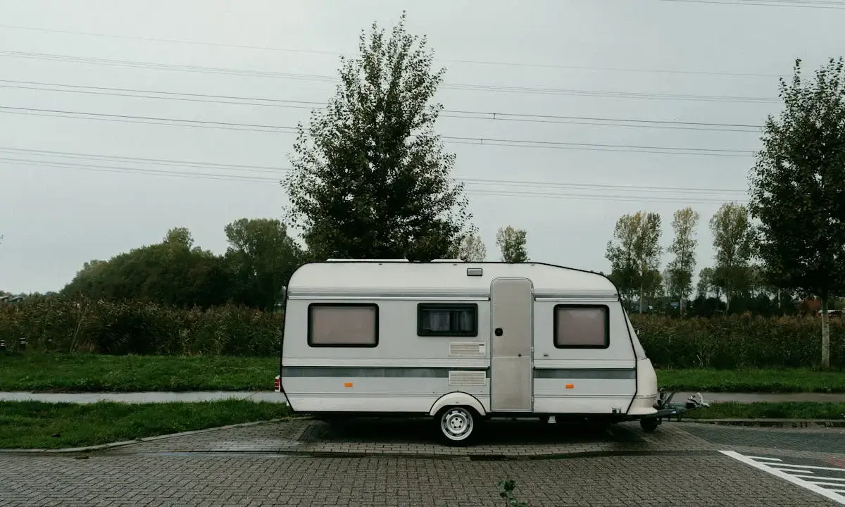 Small travel trailer parked on a paved lot.