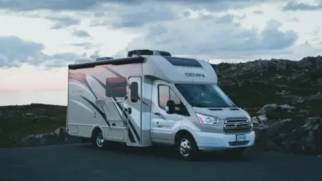 RV parked by the roadside at sunset.