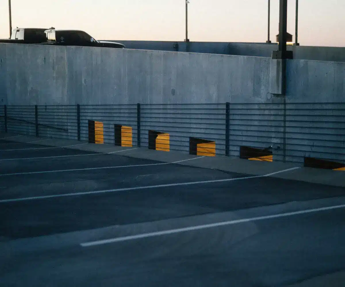 Empty parking lot at sunset with a car above.