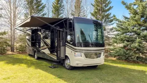 Luxury Class A motorhome parked on a grassy site.