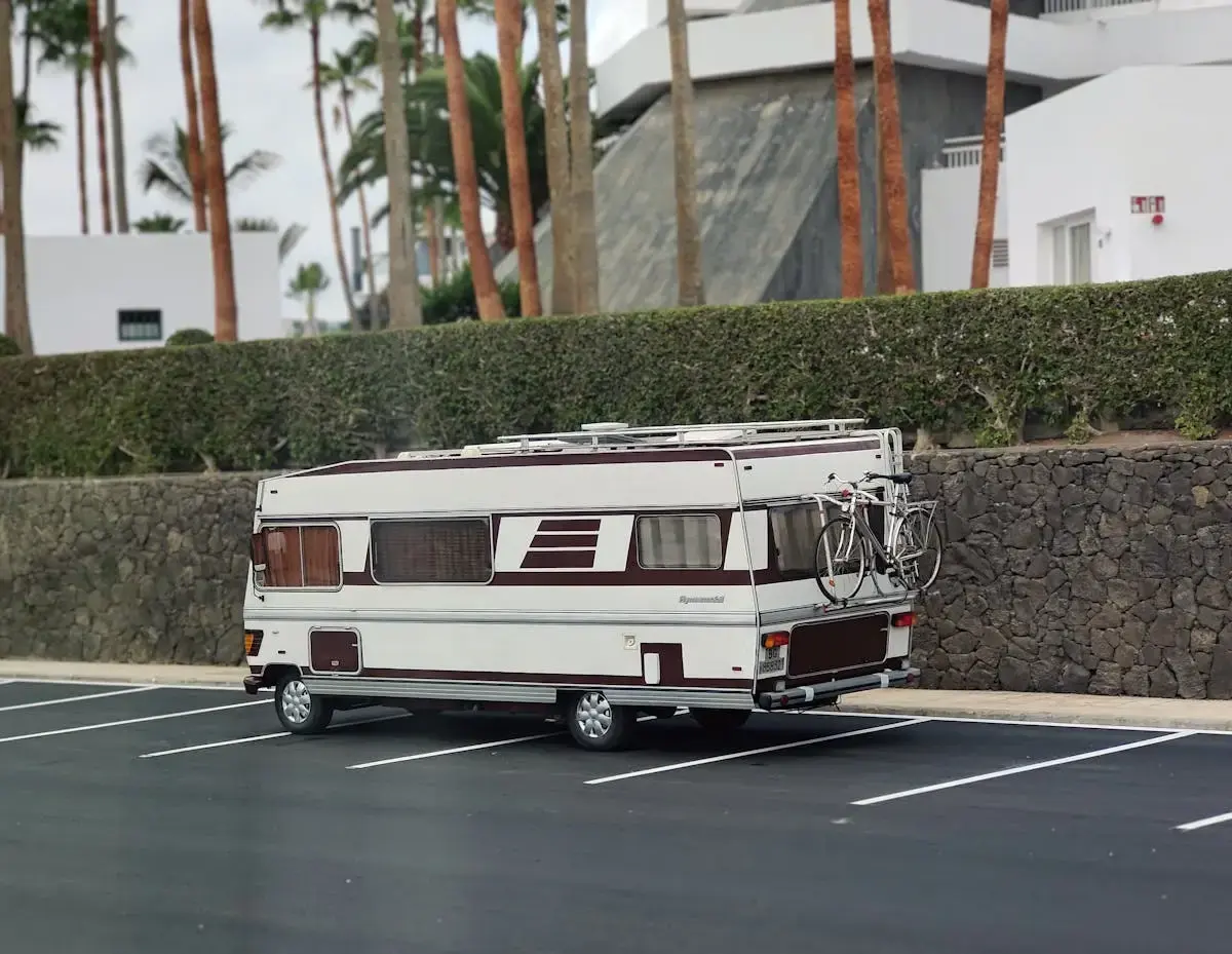 Motorhome parked in an empty lot with a bicycle mounted on the back.