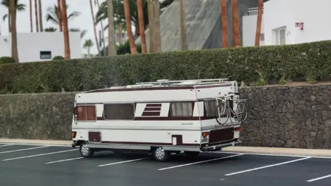 Motorhome parked in an empty lot with a bicycle mounted on the back.