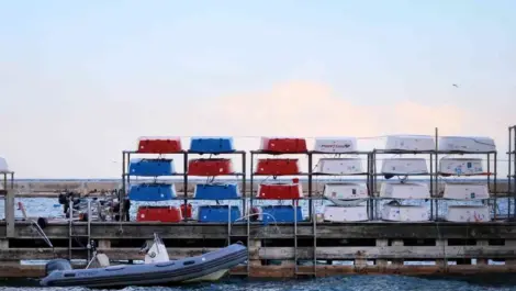 Small boats stacked on racks by the dock
