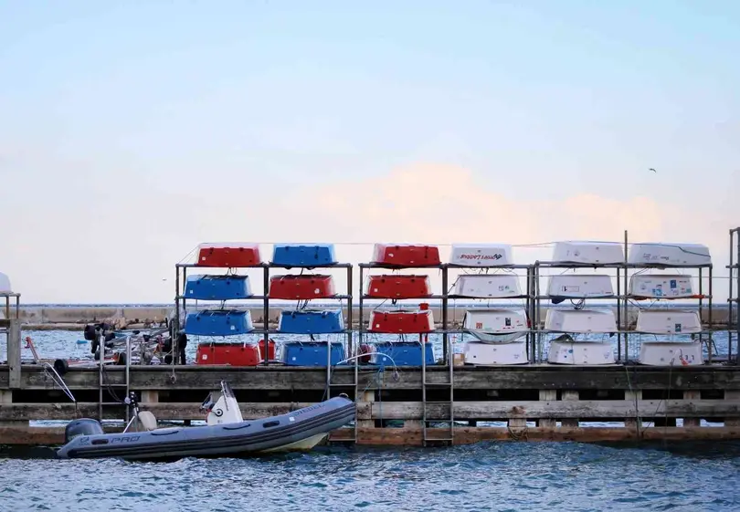 Small boats stacked on racks by the dock