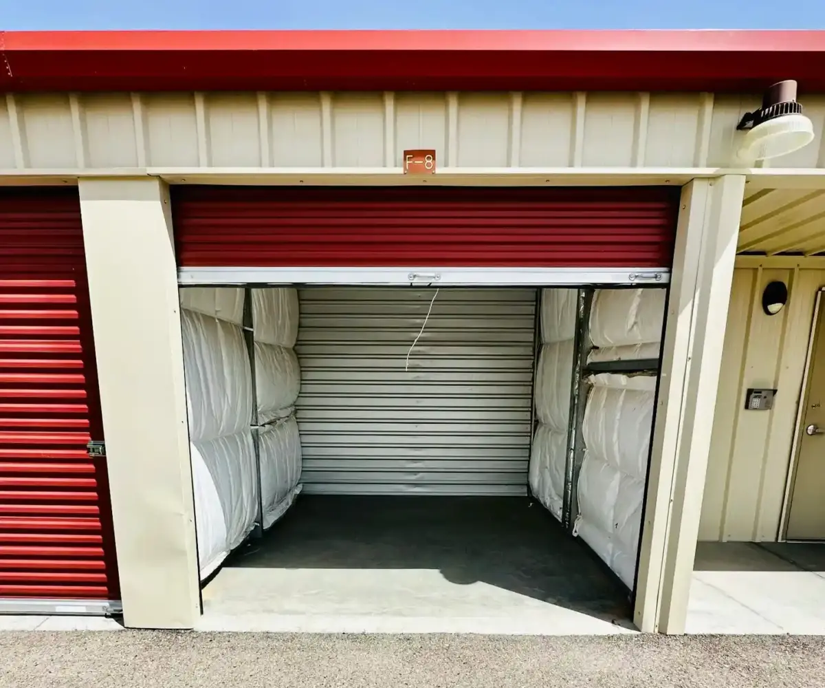Open self-storage unit with red roll-up door