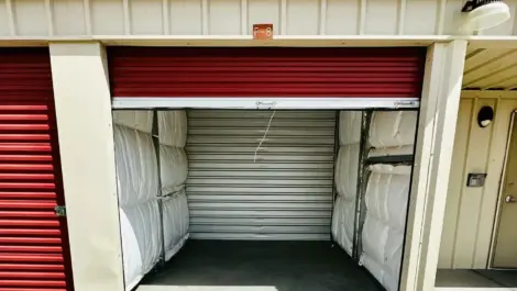 Open self-storage unit with red roll-up door