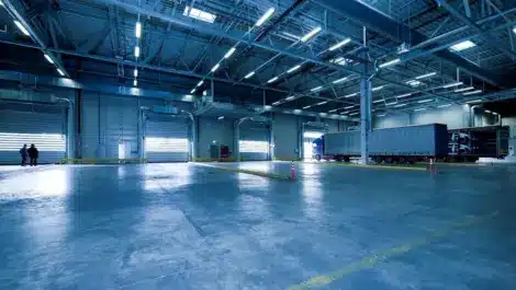 Modern indoor warehouse facility with polished concrete flooring, high ceilings.