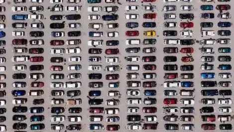 Aerial view of a crowded parking lot filled with rows of cars.