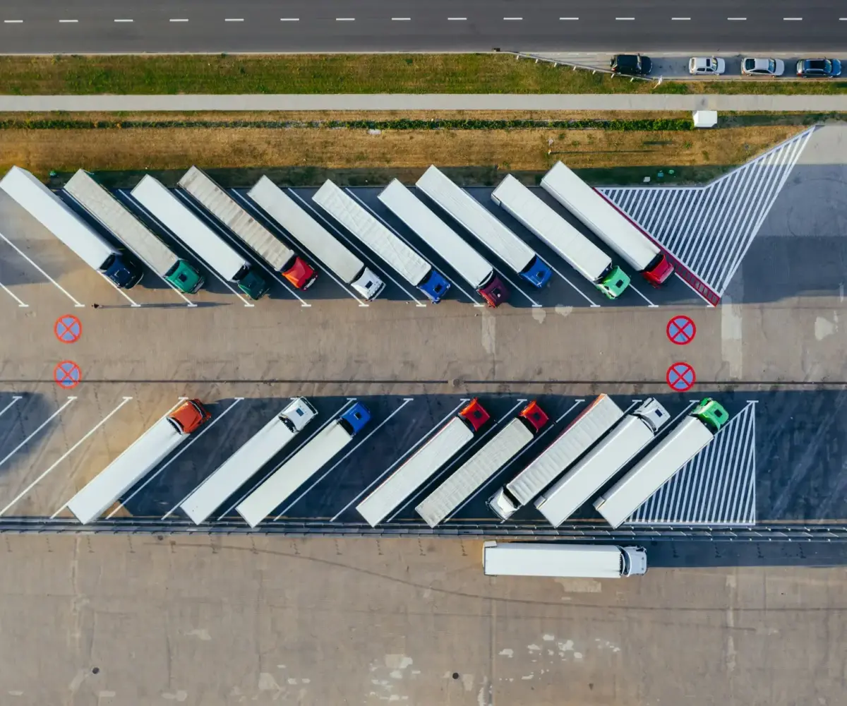 Aerial view of commercial truck parking lot with semi-trucks parked.