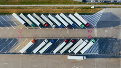 Aerial view of commercial truck parking lot with semi-trucks parked.