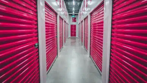 Indoor hallway lined with bright red storage unit doors.