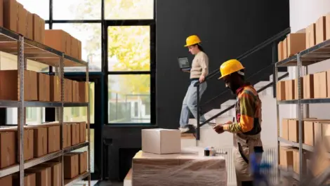 Workers organizing boxes in indoor storage area