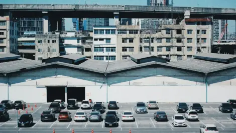 Cars parked outside a warehouse in city.