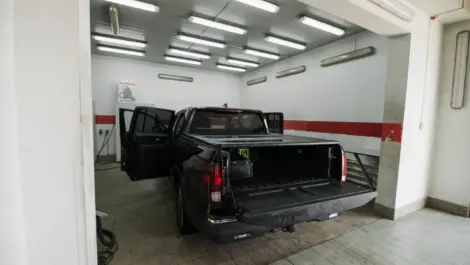 Black pickup truck parked in indoor storage garage.