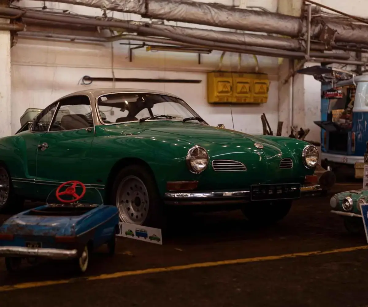 Classic green vintage car stored inside a garage.