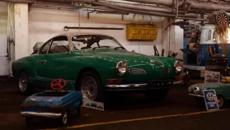 Classic green vintage car stored inside a garage.