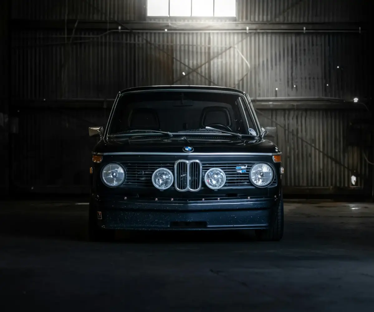 Black BMW inside secure indoor vehicle storage facility.