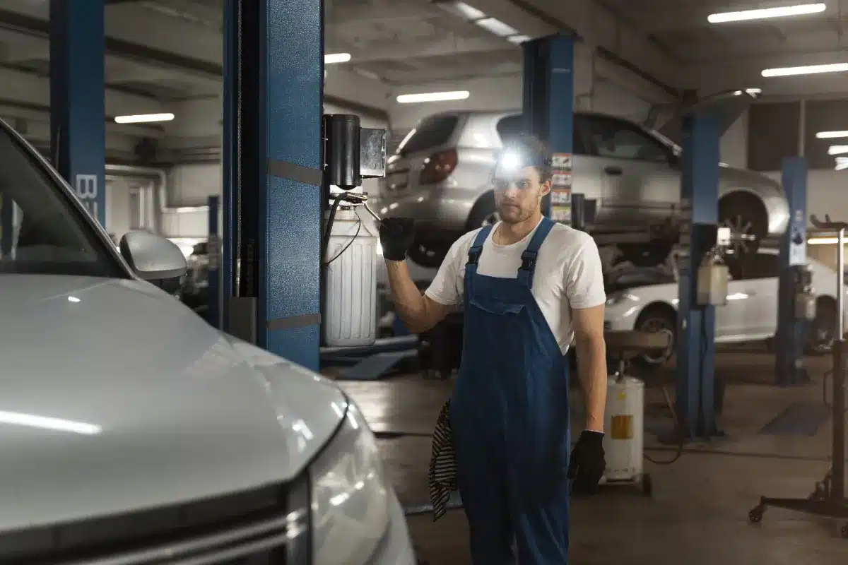 Mechanic inspecting car inside auto repair shop