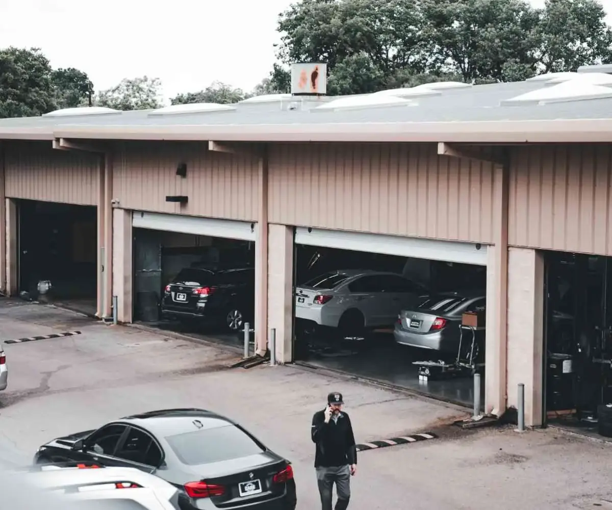 Classic car storage facility with multiple vehicles parked inside garage.
