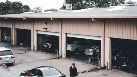 Classic car storage facility with multiple vehicles parked inside garage.