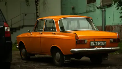 Classic orange vintage sedan stored outdoors.