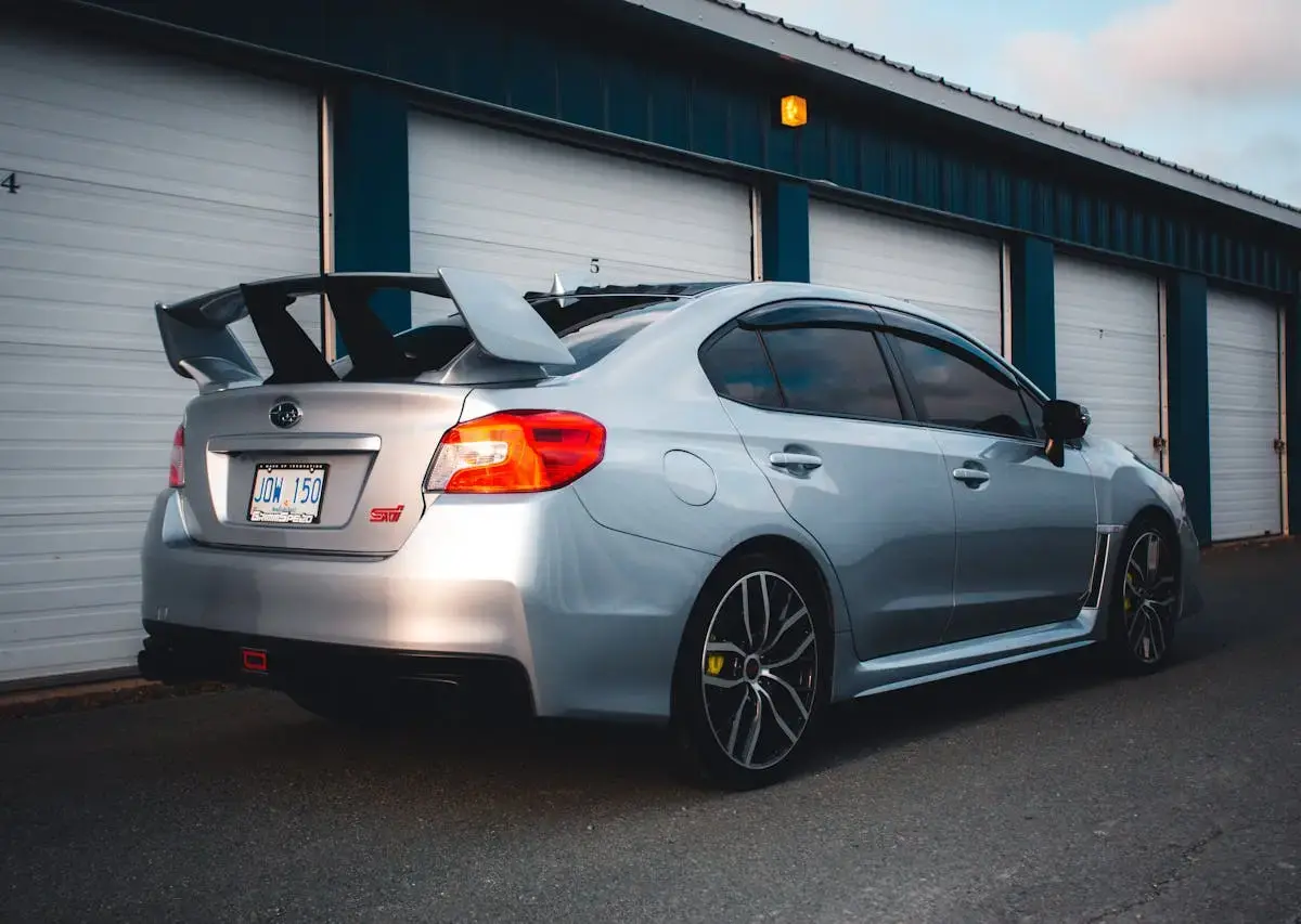 Silver sports sedan parked outside a row of storage garage units