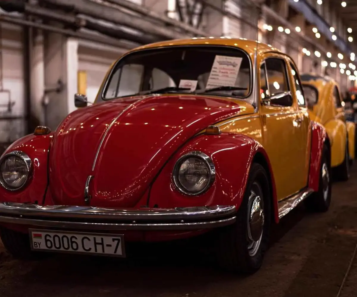Red and yellow Volkswagen Beetle classic car displayed indoors.
