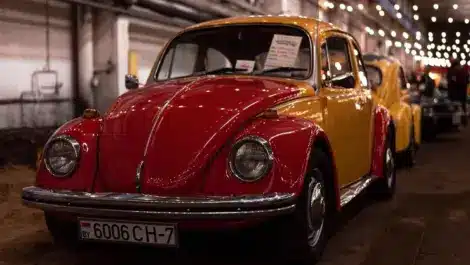 Red and yellow Volkswagen Beetle classic car displayed indoors.