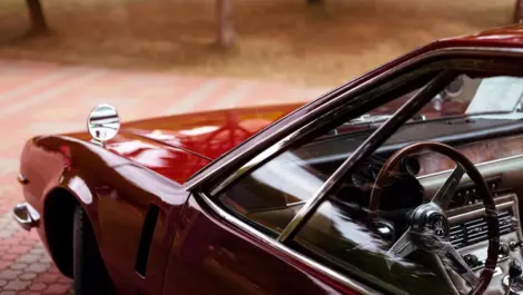 Classic car interior and steering wheel viewed through the side window