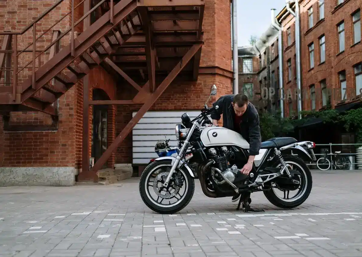 Motorcycle owner checking and maintaining a bike in an outdoor setting, highlighting ownership, upkeep, and long-term care.