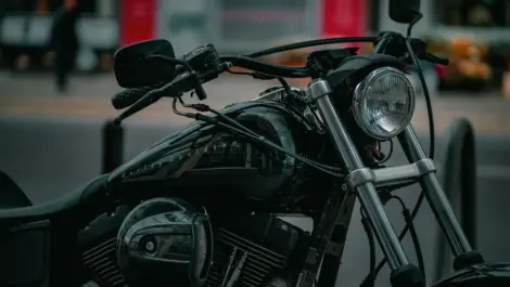 Close-up of a parked motorcycle in an urban setting, illustrating long periods without riding and storage considerations.
