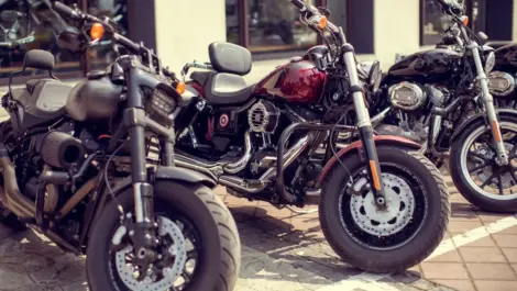 Multiple motorcycles parked outdoors in a row, illustrating public storage demand, parking considerations, and motorcycle space requirements.