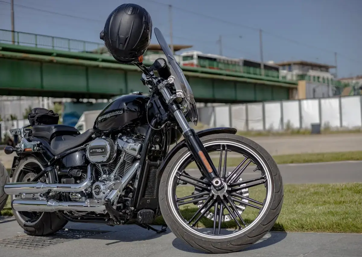 Motorcycle parked outdoors near a roadside with no cover, illustrating exposure to weather and the need for proper protection during outdoor storage.