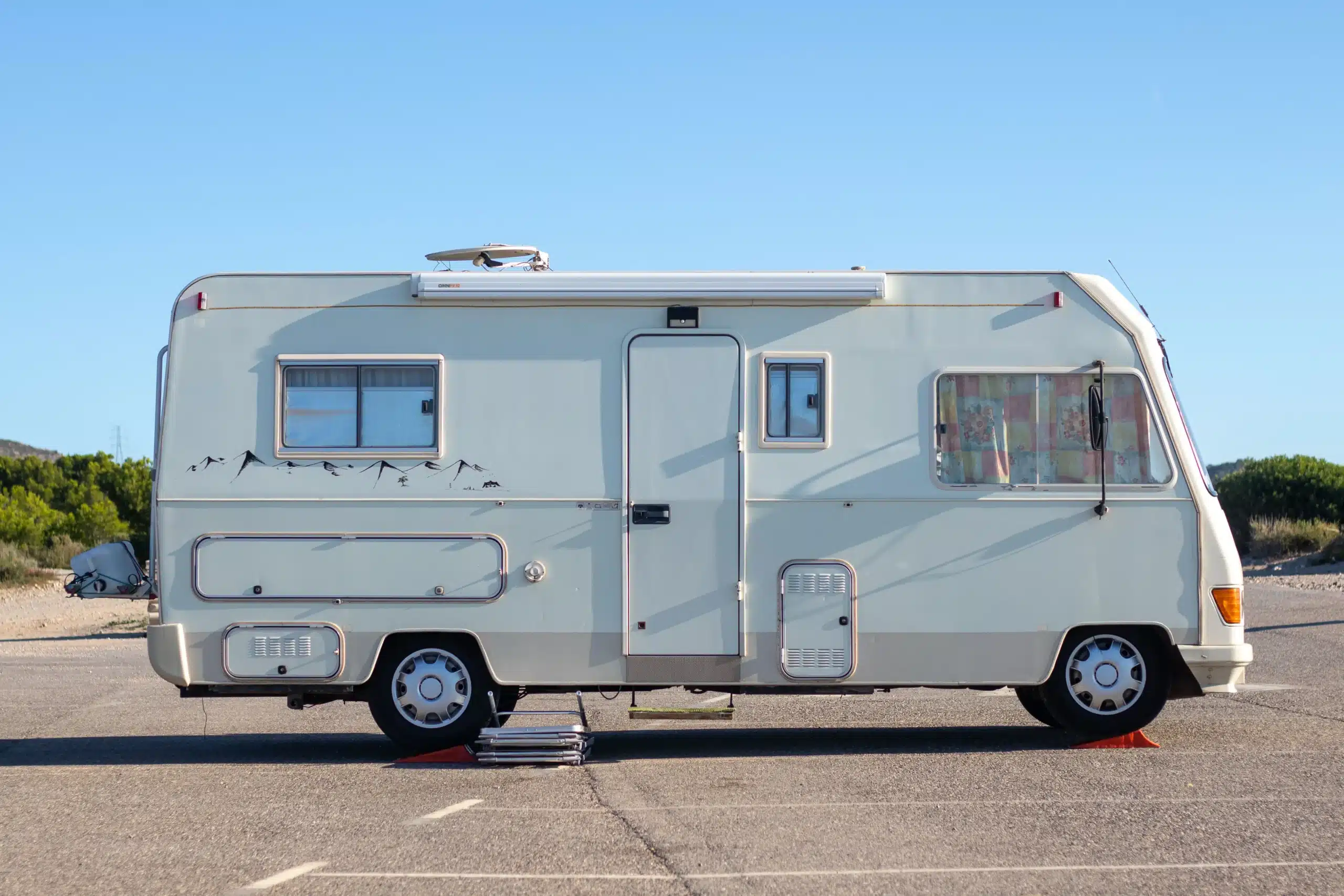 White motorhome parked at a campsite, illustrating the 2-2-2 RV travel rule of shorter driving days and longer campground stays.