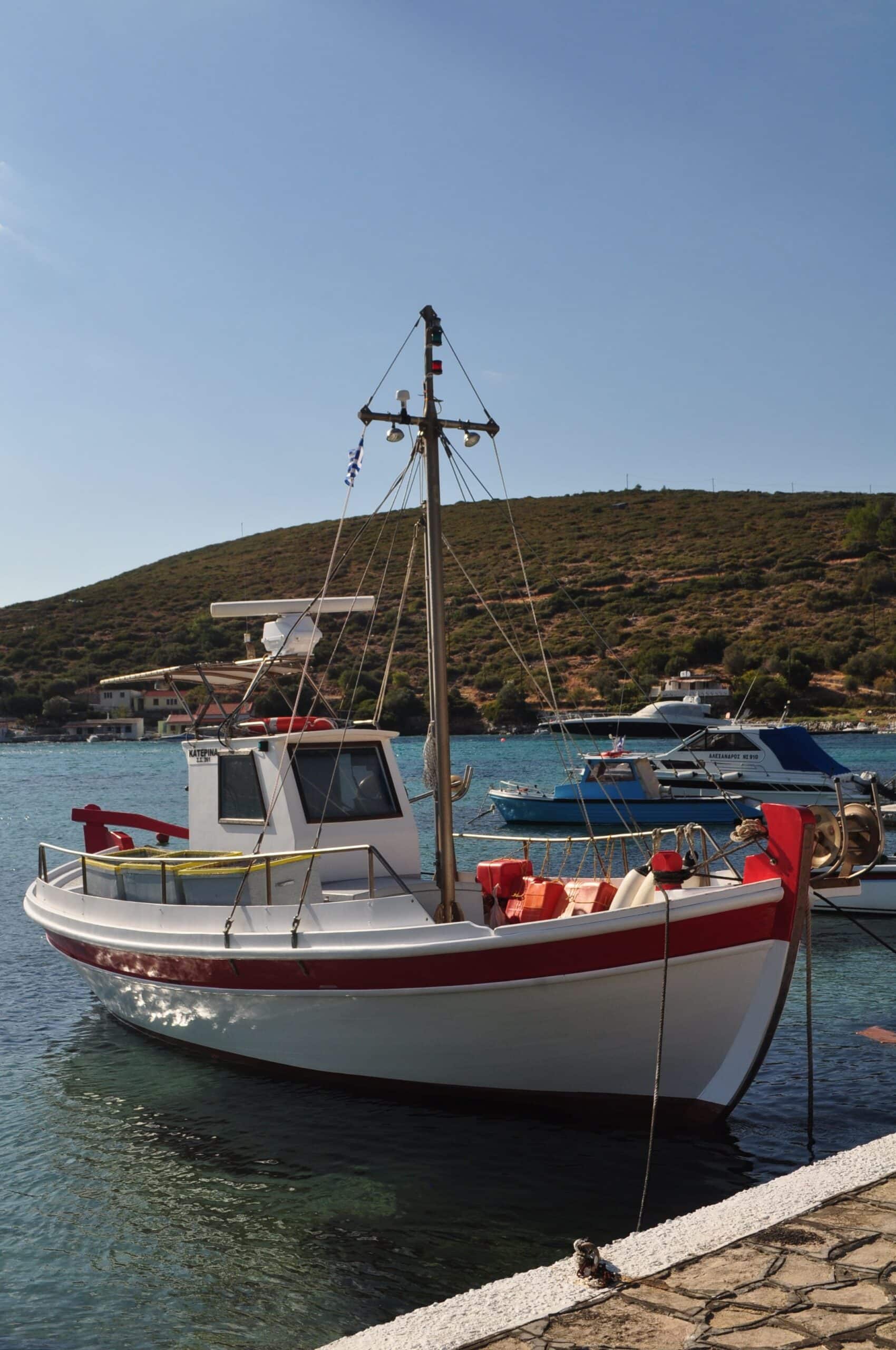 Small recreational fishing boat moored at a marina, representing an entry-level boat type with ownership costs including purchase price, insurance, maintenance, and storage.